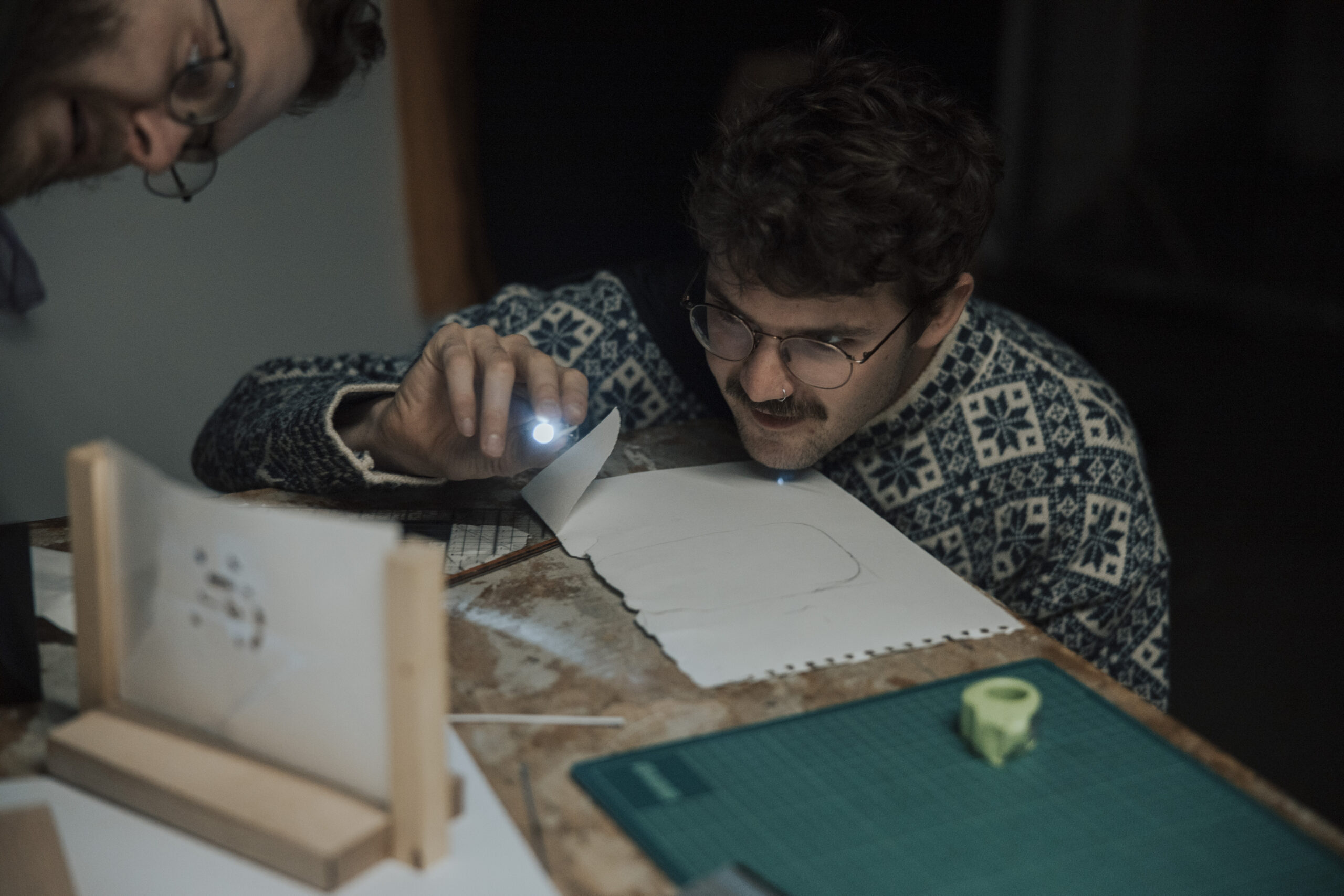 Mann mit Taschenlampe beim Lösen eines Rätsels